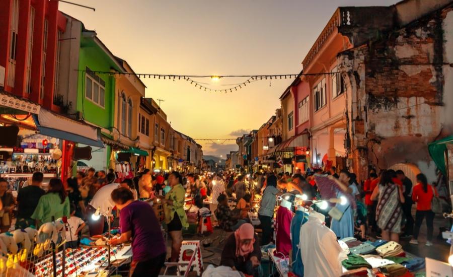 Mercato notturno affollato tra gli edifici colorati della città vecchia di Phuket