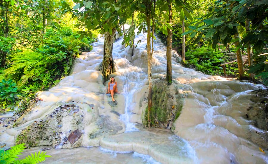 Turisti che si arrampicano sulle rocce calcaree delle cascate appiccicose di Bua Tong a Chiang Mai