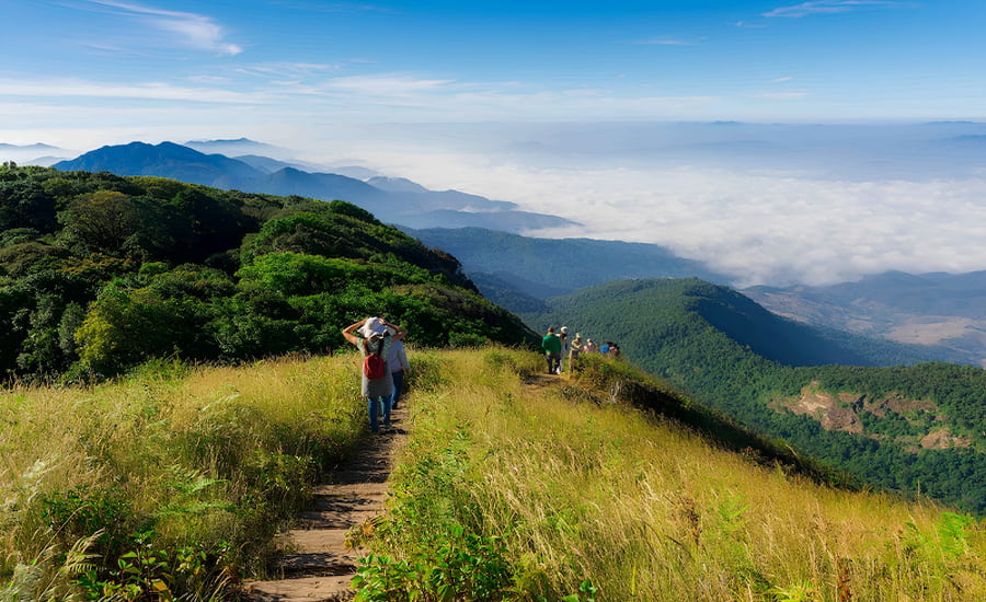 Escursionisti sul crinale del sentiero Kew Mae Pan con vista su un mare di nuvole a Chiang Mai