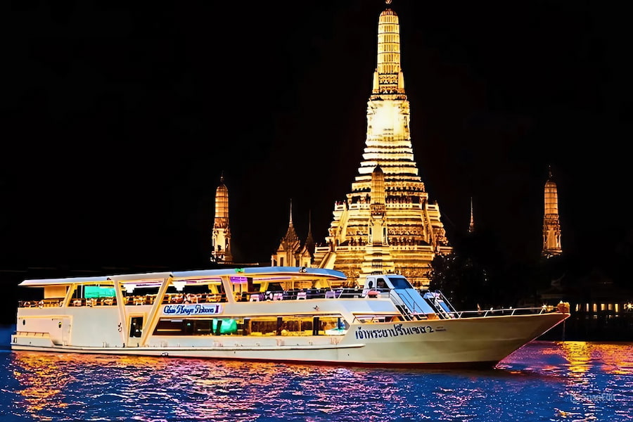 Una lussuosa nave da crociera illuminata che naviga sul fiume Chao Phraya di notte