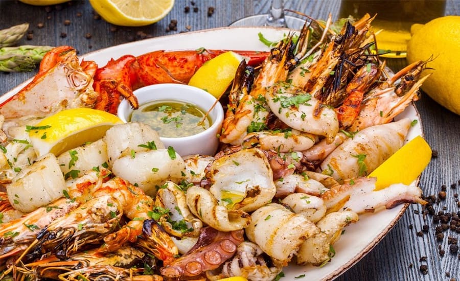 Piatti a base di pesce fresco nei mercati di street food in Thailandia