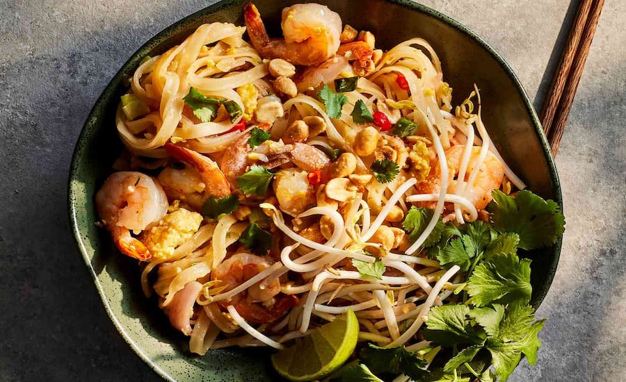 Delizioso piatto di Pad Thai saltato nel wok con gamberi e arachidi