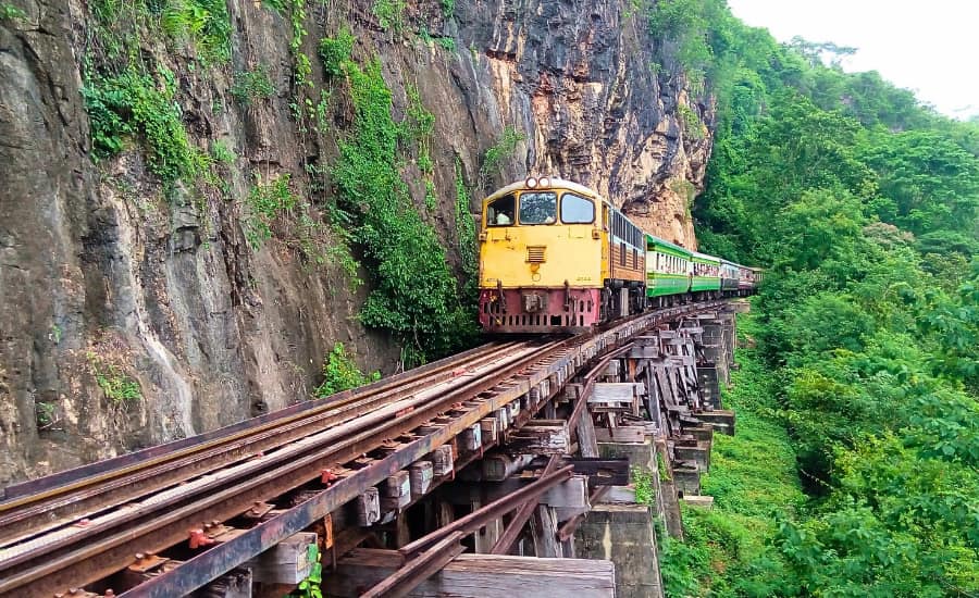 Treno storico in viaggio lungo i binari panoramici a Kanchanaburi
